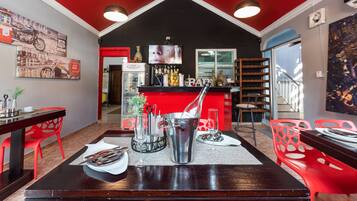 A restaurant with a red and black color scheme, a bar area, and red chairs.