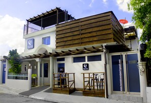 A two-story building with a wooden facade, a balcony, and a sign indicating a restaurant.