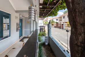 A hotel corridor with a long reception desk, a "Welcome" sign, and a view of the street outside. - Hotel Casa Jum (Santiago de los Caballeros)