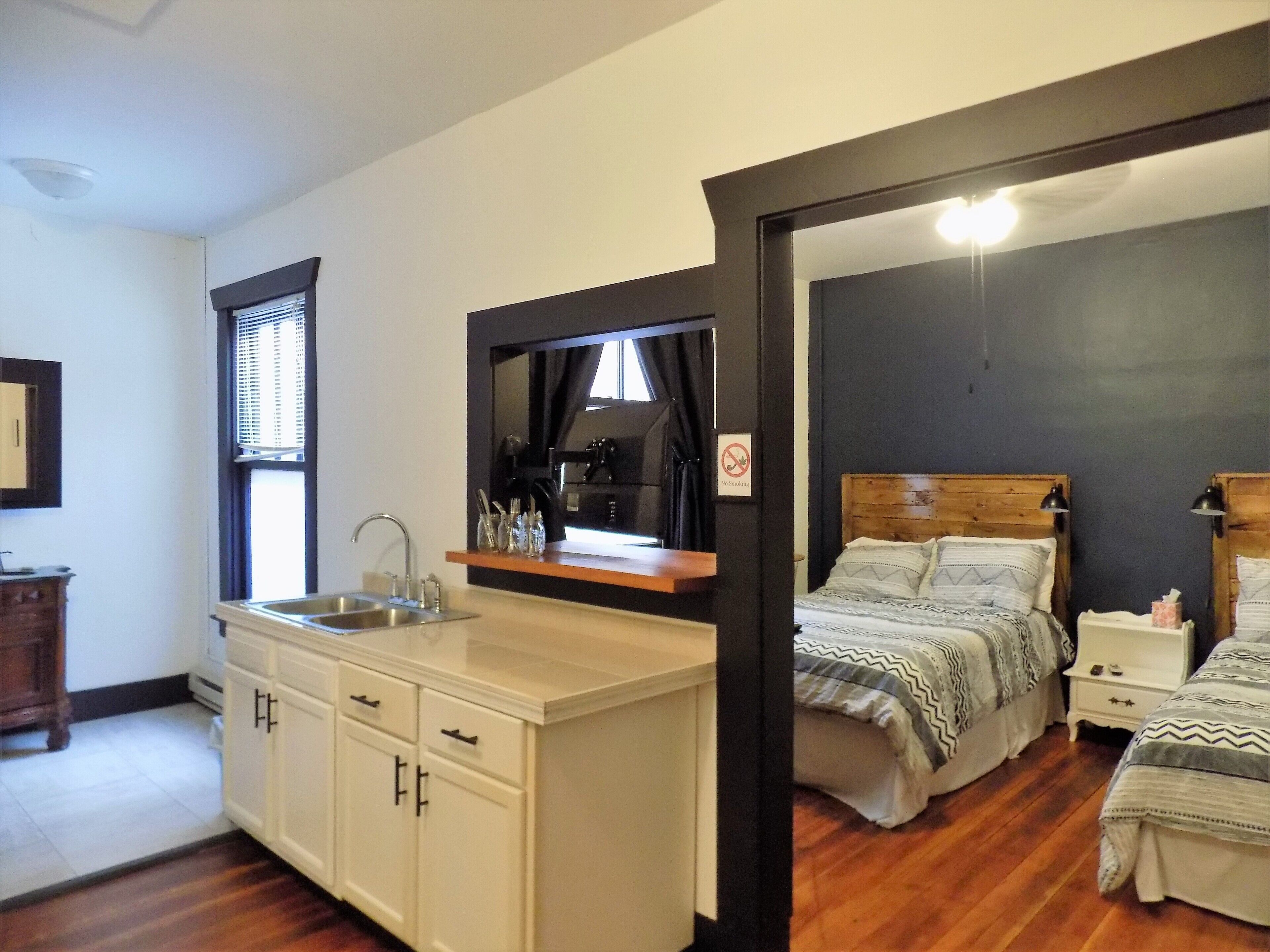 Suite Deluxe, 2 camas Queen size, para no fumadores | Área de sala de estar | Televisión LCD de 24 pulgadas con canales vía satélite y televisión 