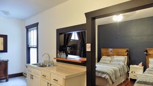 A bedroom with a wooden headboard, a bedside table, and a nightstand. - The Landmark Inn (Fairfield)