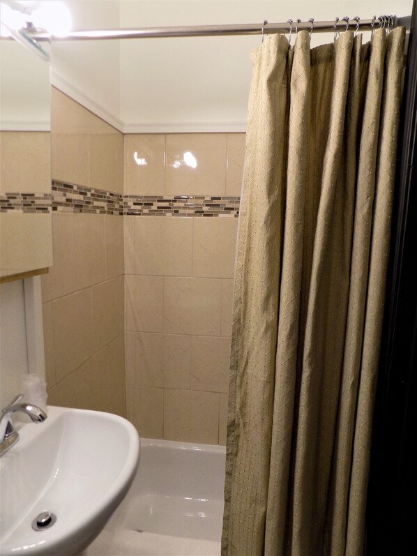 Ein Badezimmer mit Waschbecken, Spiegel und Duschvorhang.
