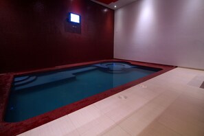 Zona de spa con jacuzzi y suelo de baldosas.