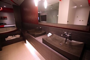 Un baño moderno con dos lavamanos, un espejo grande y una bañera.