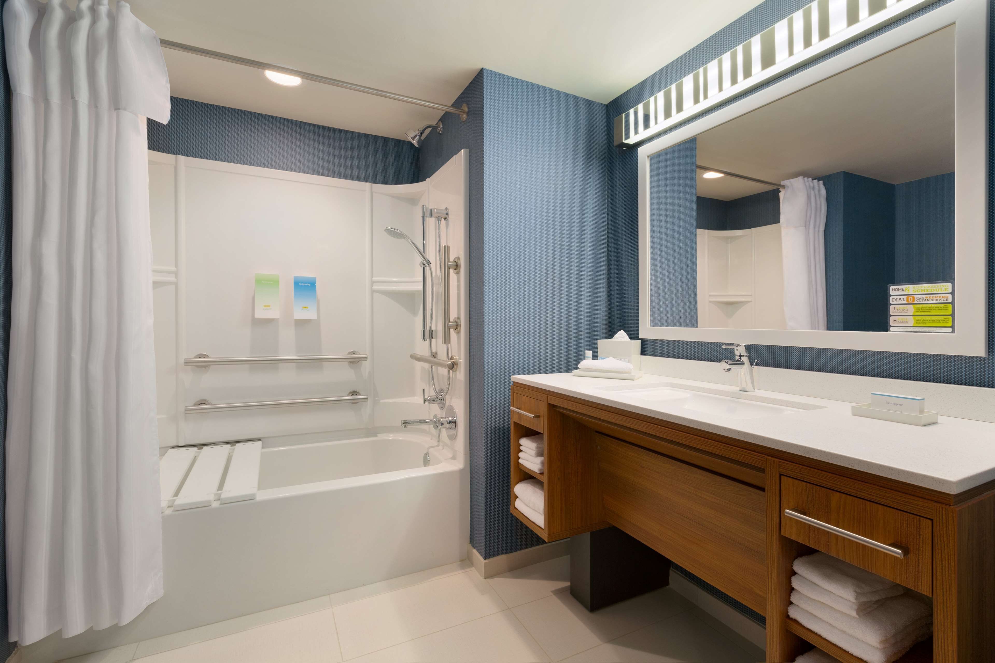 A modern bathroom with a bathtub, shower, and vanity.
