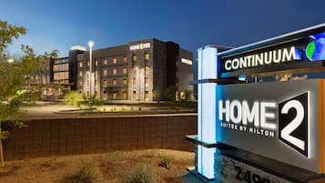 Une enseigne d’hôtel avec les inscriptions « CONTINUUM » et « HOME 2 SUITES BY HILTON », le tout illuminé.