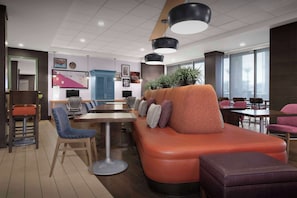 Relax in a stylish lounge area with a sofa, chair, and ottoman, perfect for casual dining or meetings.