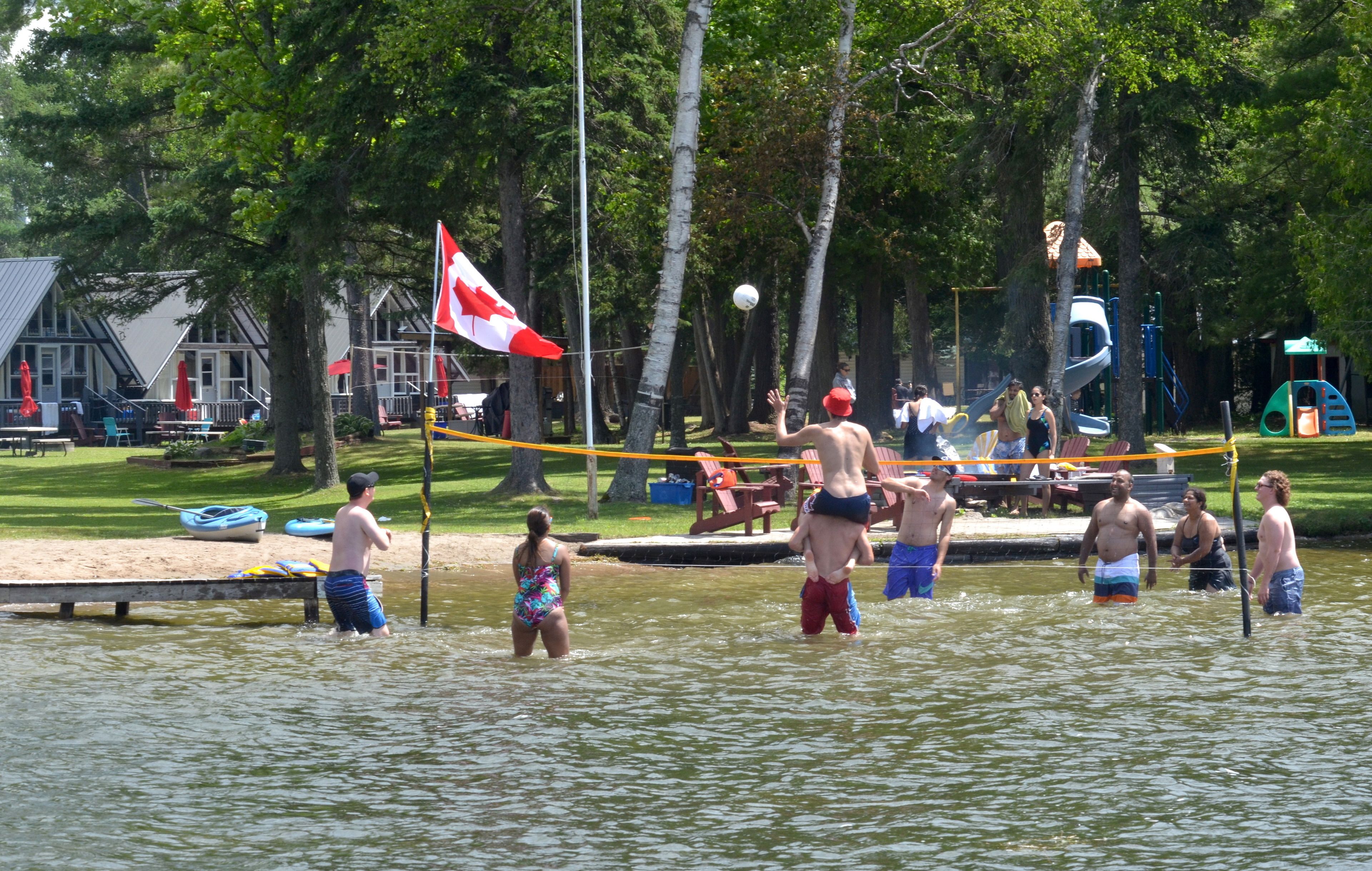 Eine Uferlandschaft mit Steg, einer Flagge und einem Spielplatz.