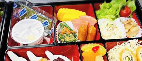 A bento box with various food items including rice, vegetables, and meat.