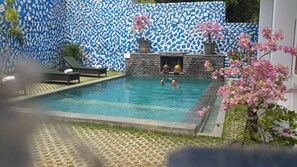 Una piscina al aire libre, tumbonas
