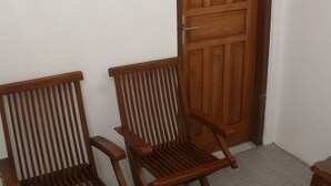 Una habitación con dos sillas de madera y una puerta de madera que tiene la letra 'M'.
