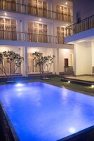 Una piscina al aire libre, sillones reclinables de piscina