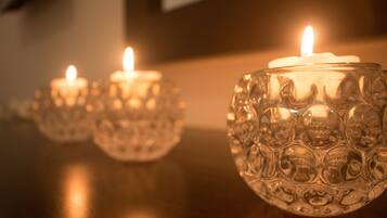 Tres candelabros de vidrio con velas encendidas sobre una superficie de madera.