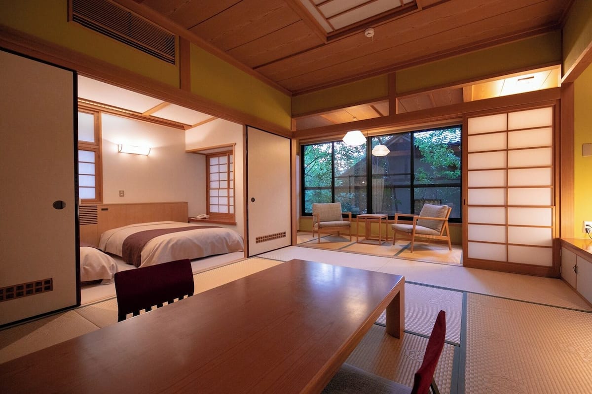 Una habitación tradicional japonesa con suelo de tatami, una mesa de madera baja y una puerta corrediza estilo shoji.