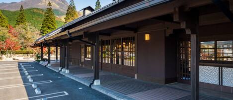 A traditional building with a covered walkway and a parking area.