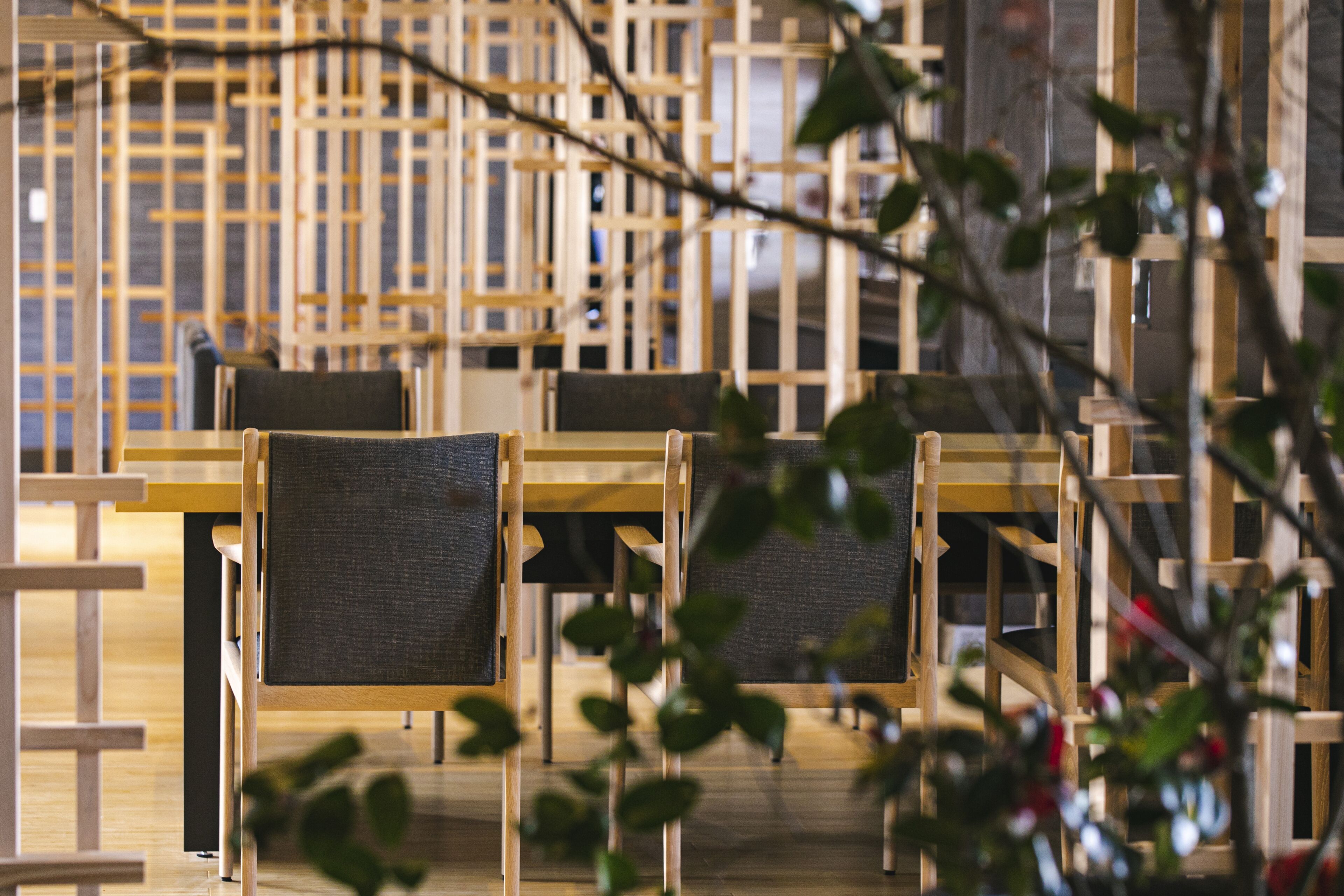 A modern interior with wooden furniture and a lattice structure in the background.