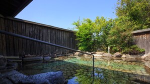 A wooden deck with a clear pool, surrounded by rocks and trees. - Yufuin Baien Garden Resort (Yufu)