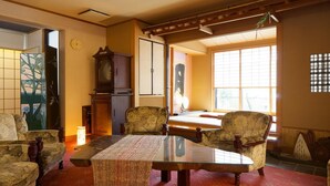 A traditional Japanese room with tatami flooring, a low table, and two chairs. - Futabaso (Hikone)