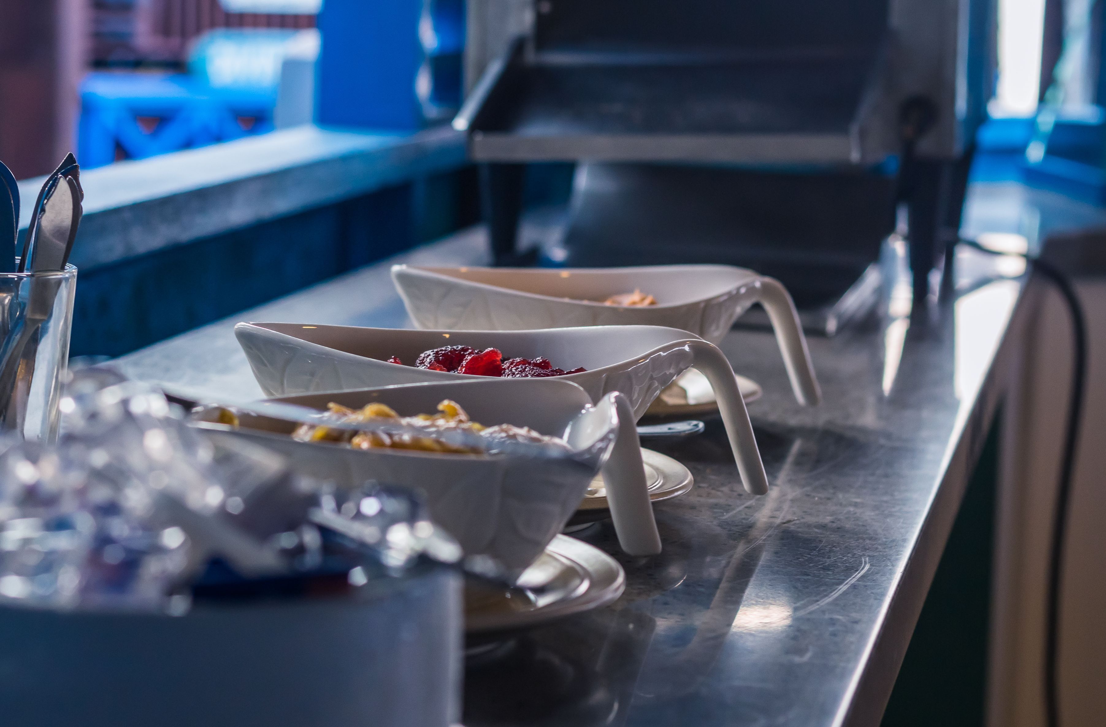 A buffet setup with various dishes and utensils.