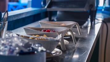 A buffet setup with various dishes and utensils.