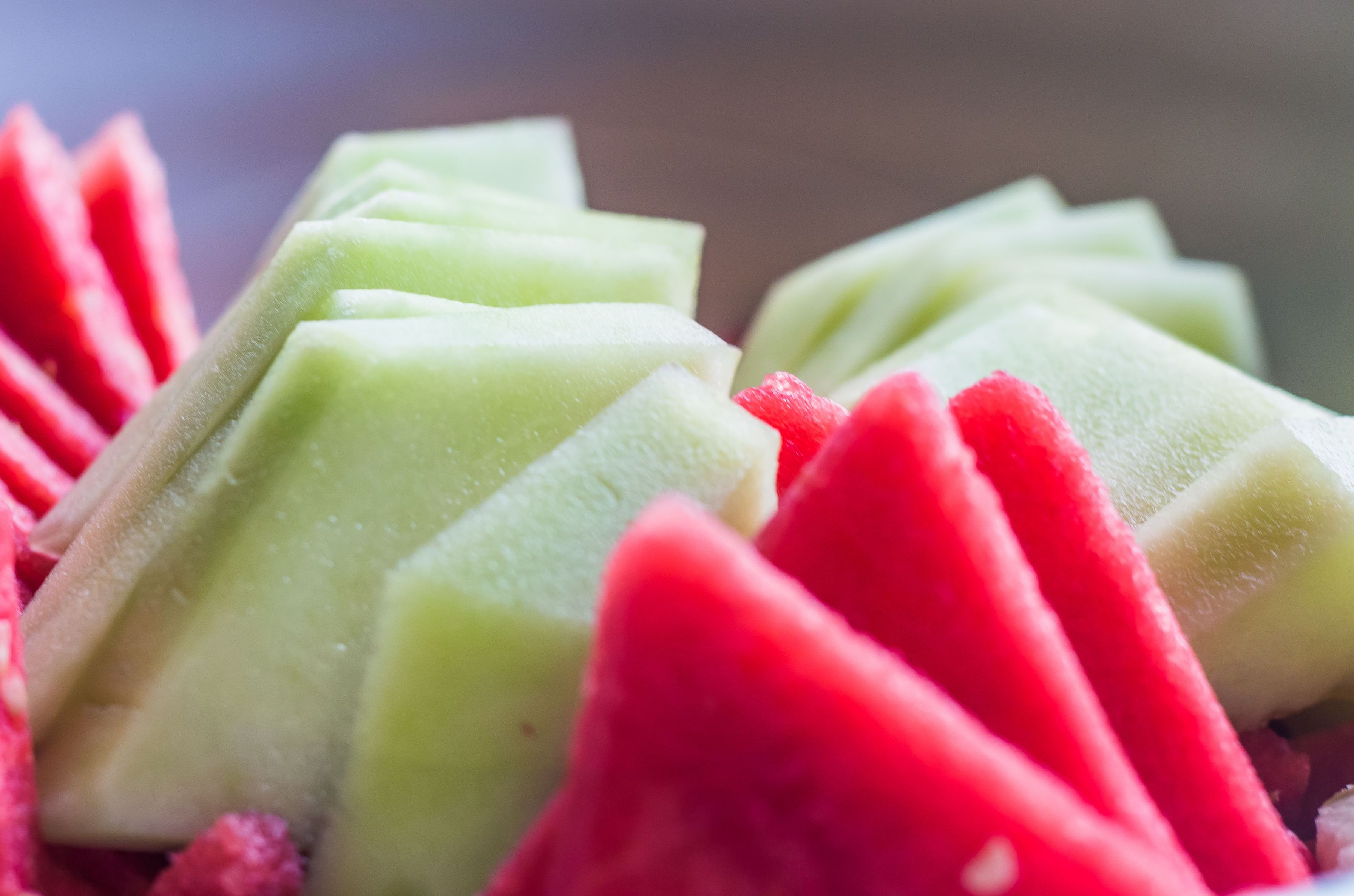 Een close-up van een dessert met groene en rode, driehoekige stukjes.