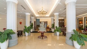 A spacious lobby with a central statue, large columns, and potted plants. - Paradise Hotel (Phnom Penh)