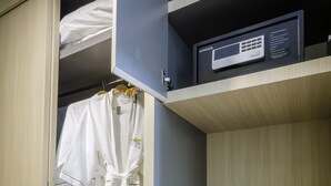 A hotel room with a wardrobe containing a robe, a microwave, a kettle, and a tray with a cup and saucer. - Paradise Hotel (Phnom Penh)