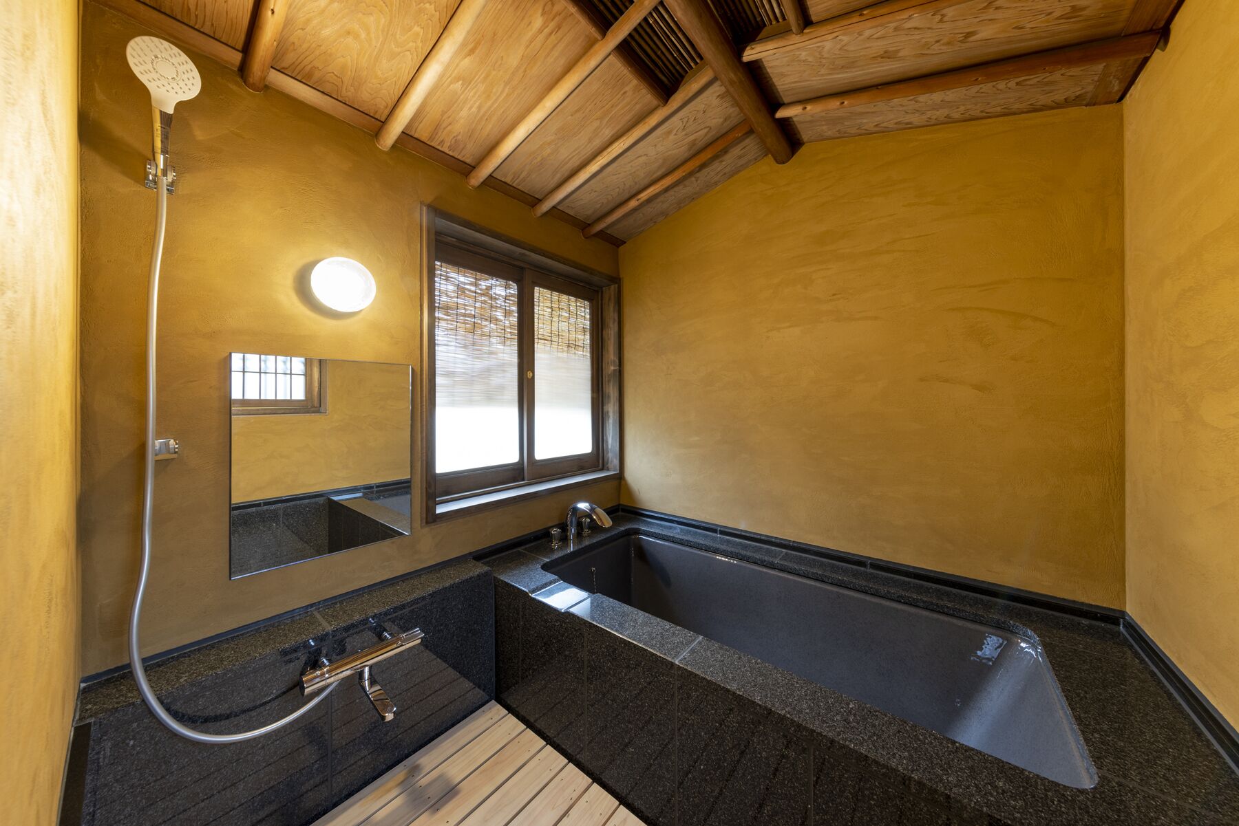 Un baño con bañera, ducha, lavabo y espejo.