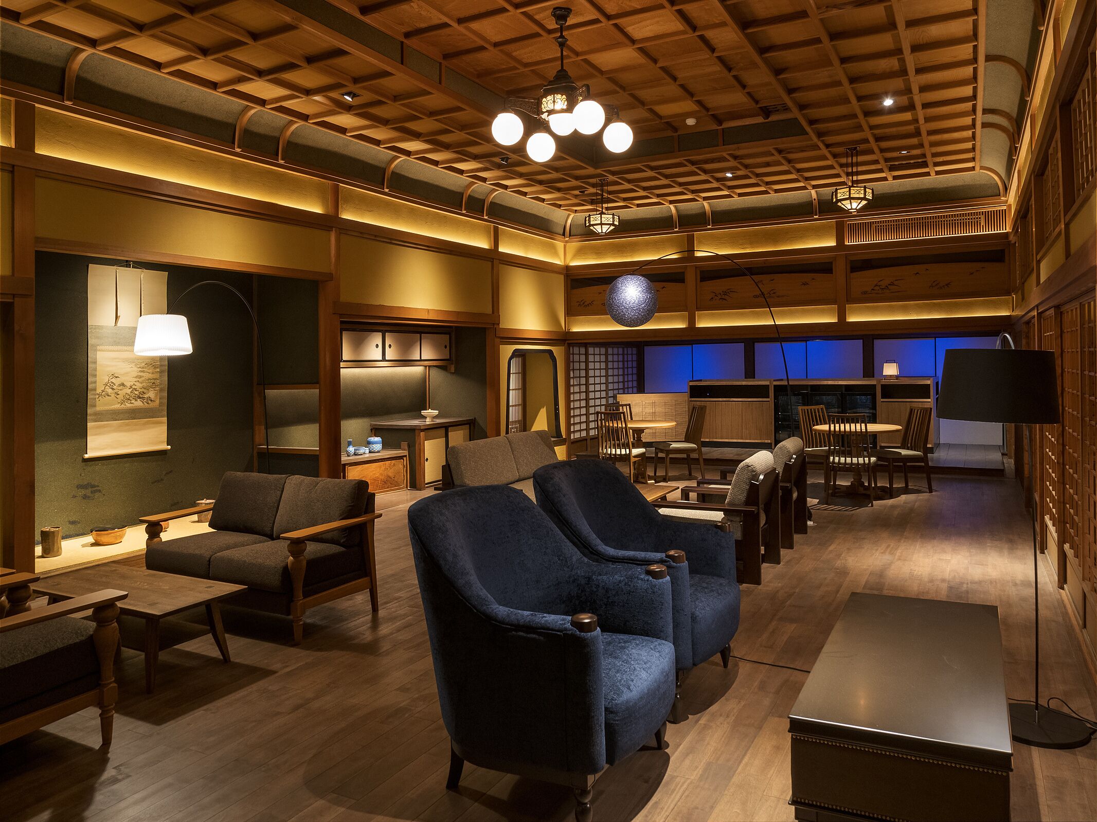 A spacious living area with a high ceiling, wooden beams, and a variety of seating options including sofas and chairs.