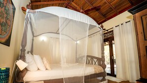 A bed with a canopy, a bedside lamp, and a wooden headboard. - The Waves Beach Chalets (Tangalle)