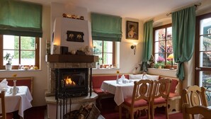 Una habitación acogedora con chimenea, muebles de madera y cortinas verdes.