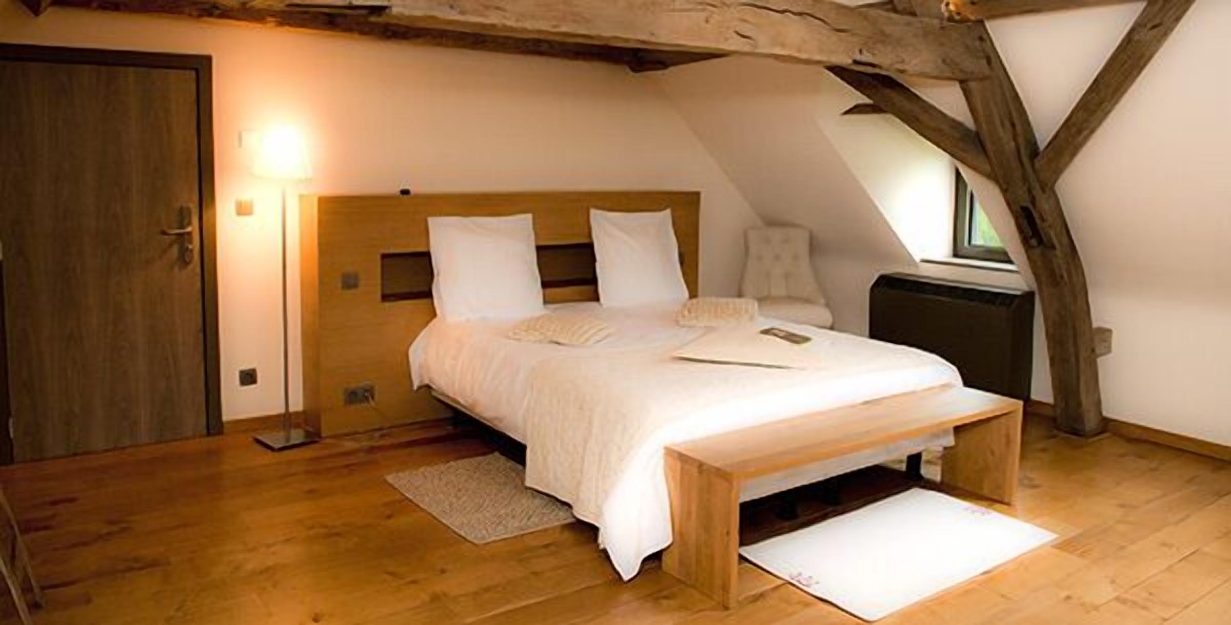Un dormitorio con una cama de madera, una mesita de noche y un ventanal.