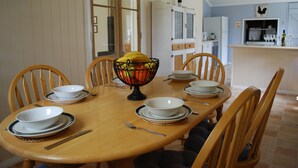 A dining table set with plates, bowls, and a fruit bowl. - Twisted Gum Cottage (Ballandean)