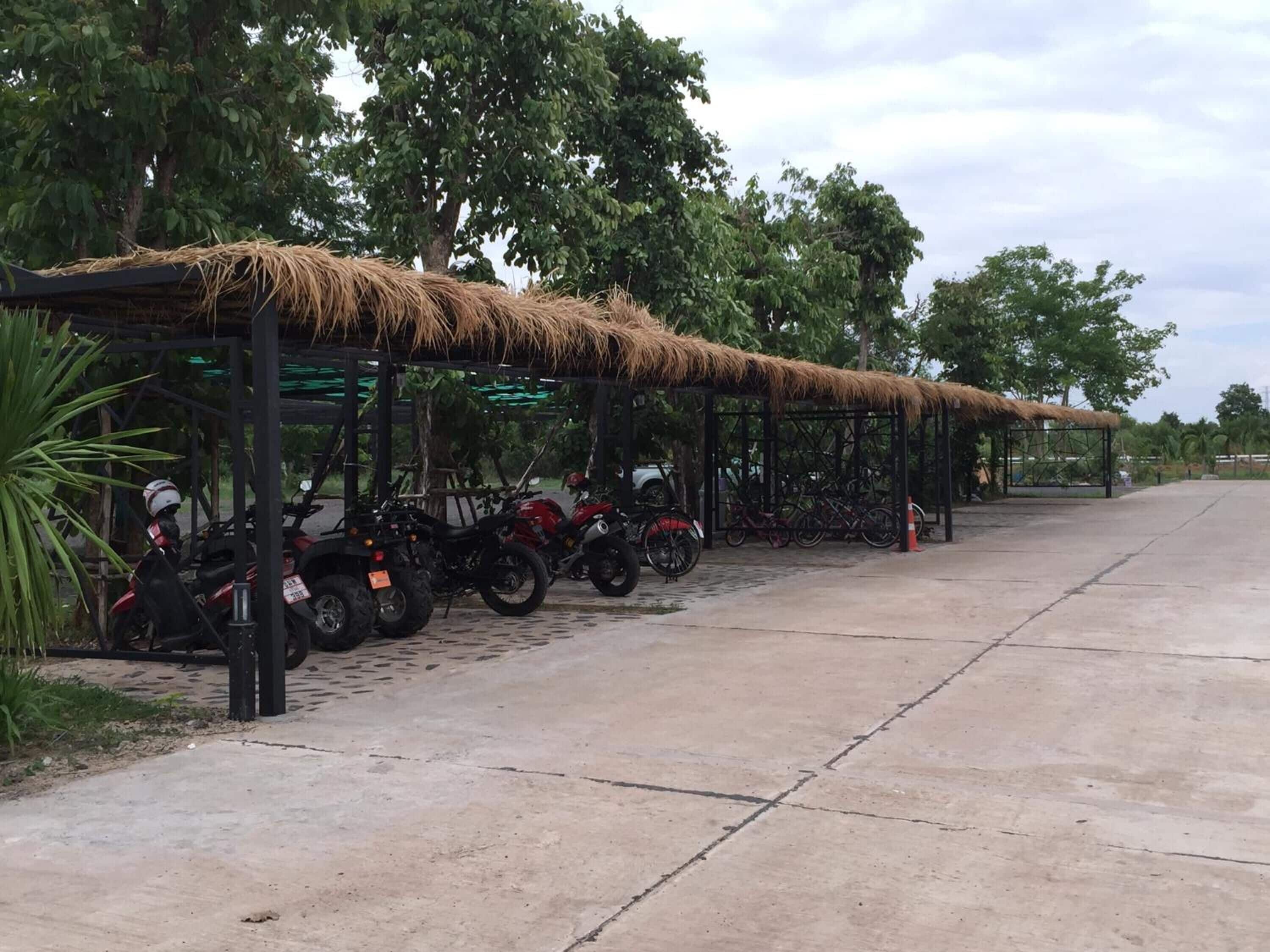 Un estacionamiento techado con vehículos todo terreno y bicicletas.