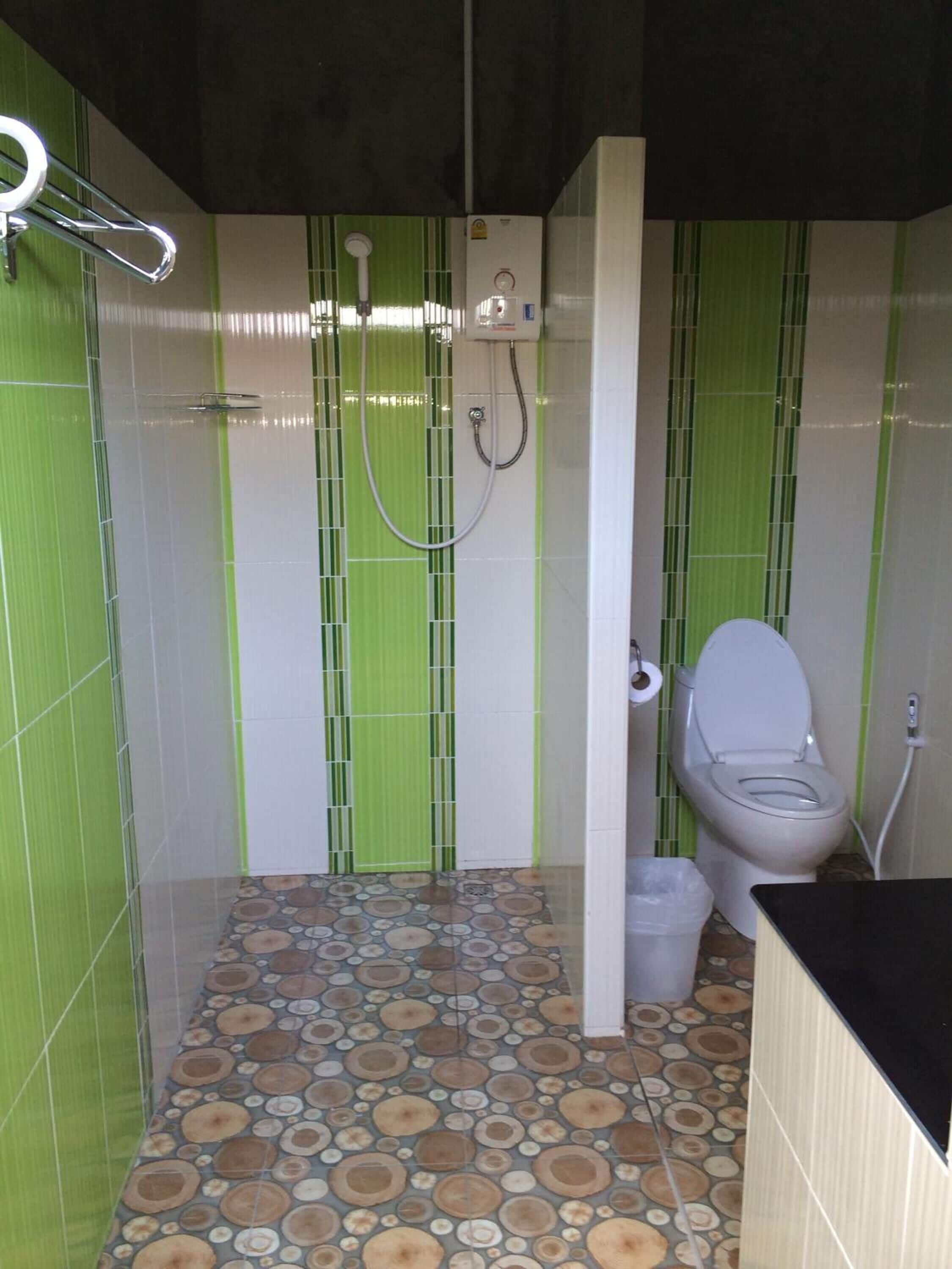 Une salle de bain avec des toilettes, une douche et un lavabo.