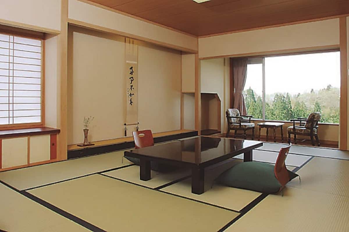 A traditional Japanese room with tatami flooring, a low table, and a sliding door.