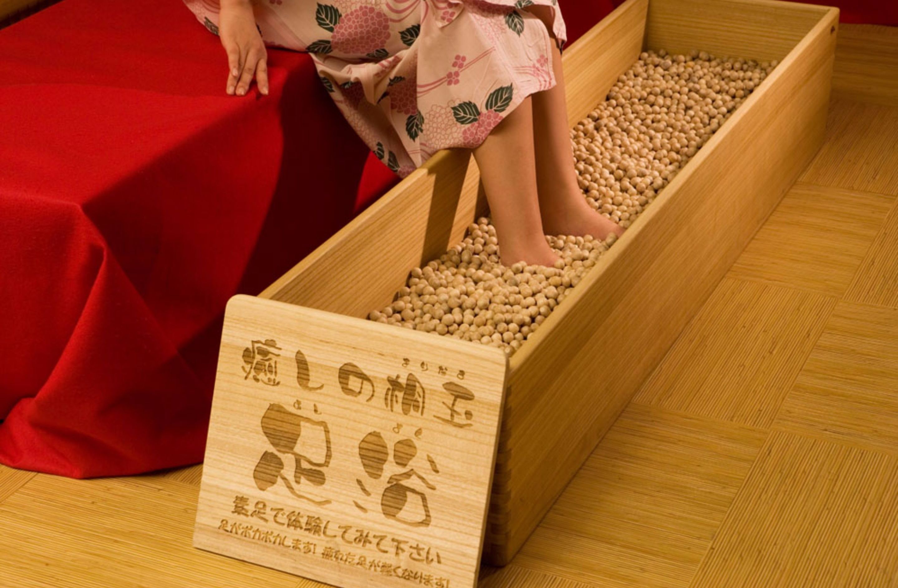 A wooden tray filled with soybeans and a wooden sign with Japanese text.