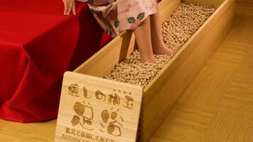 A wooden tray filled with soybeans and a wooden sign with Japanese text.