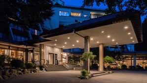 A hotel entrance with a covered walkway, steps, and a sign indicating the number of rooms.