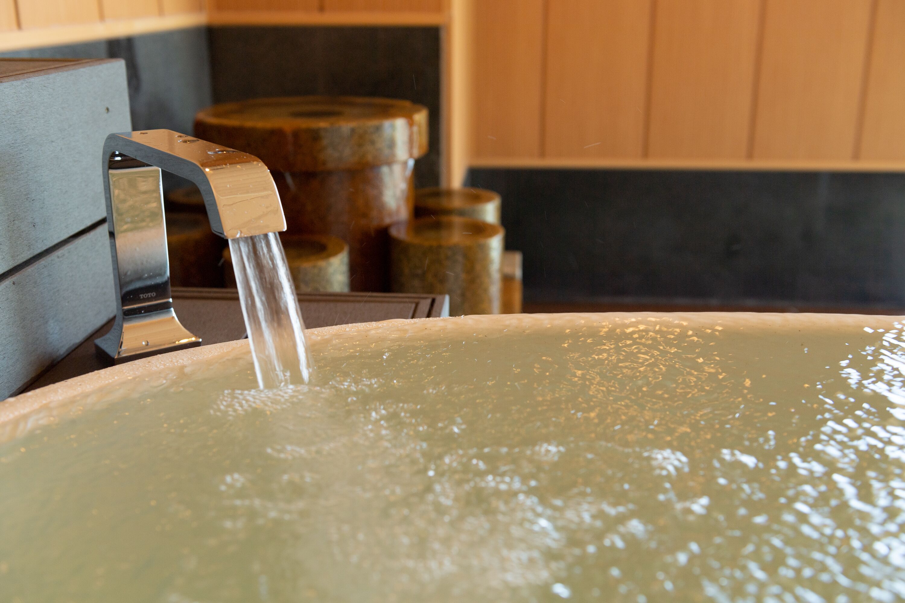 A hot tub with water flowing from a faucet.