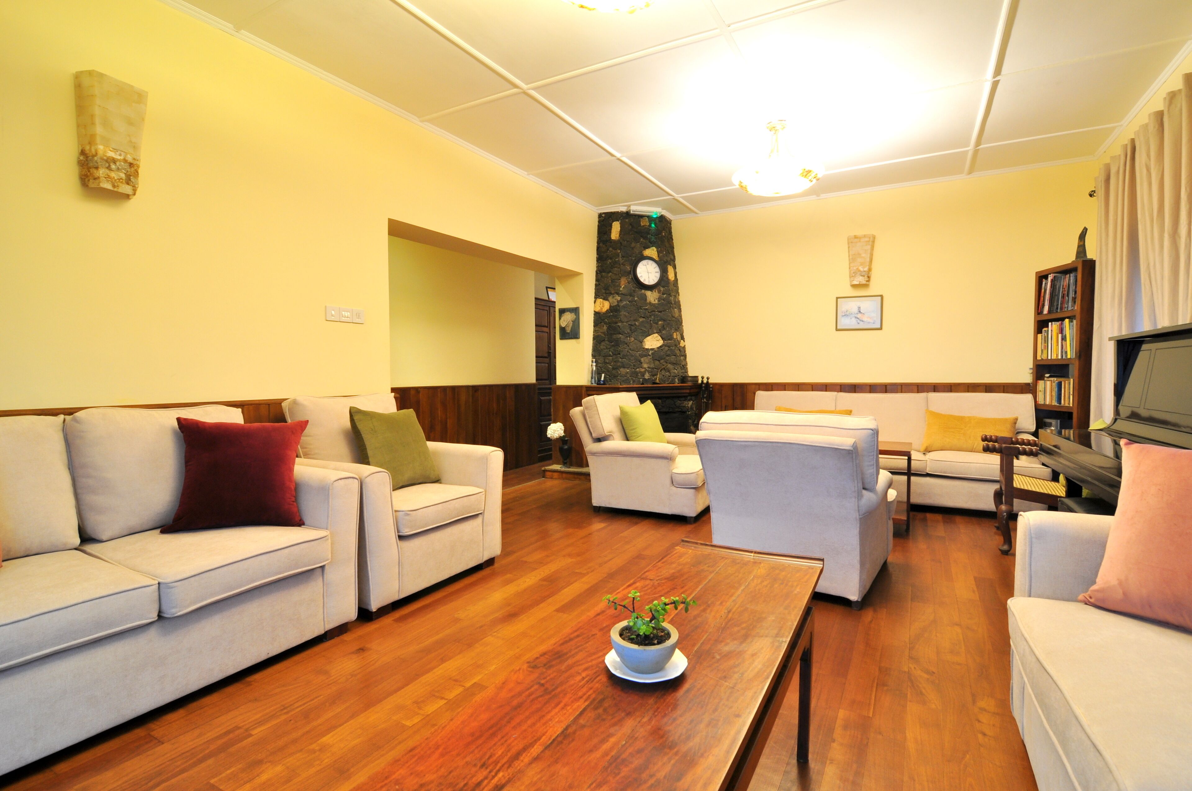 A spacious living room with a fireplace, multiple seating options, and a piano.