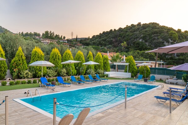 Utomhuspool, parasoller och solstolar