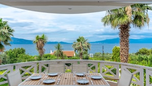 A table set for dining with a view of the sea and mountains.