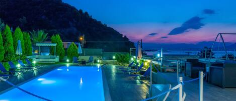 Piscine extérieure, parasols de plage, chaises longues
