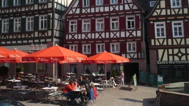 A traditional half-timbered building with outdoor seating and red umbrellas. - Hotel Ratsstube Calw (Calw)
