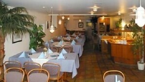 A restaurant with multiple tables and chairs, a counter with a display, and potted plants. - Hotel Ratsstube Calw (Calw)