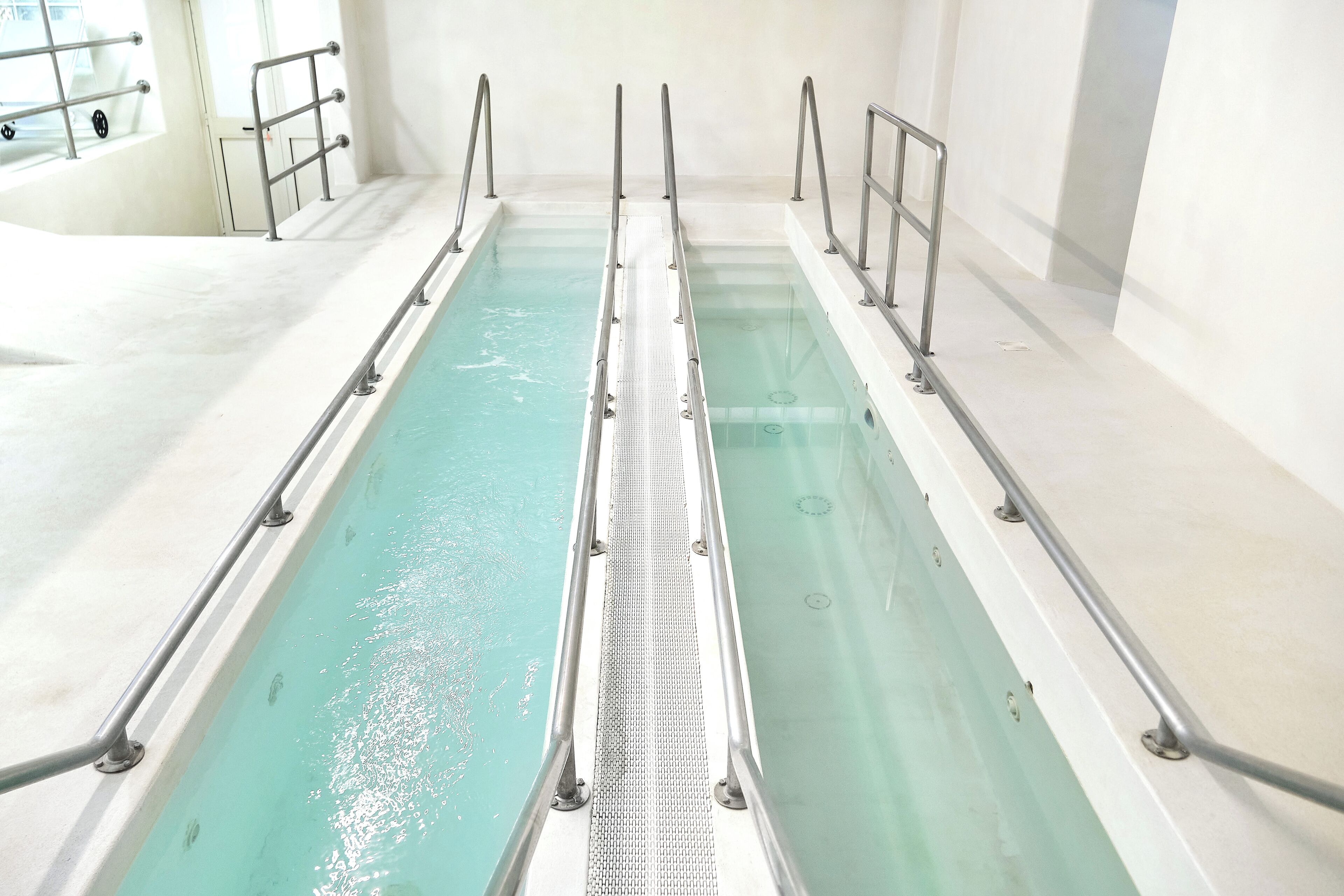 Une piscine dotée de rampes métalliques et d’une passerelle à surface antidérapante.