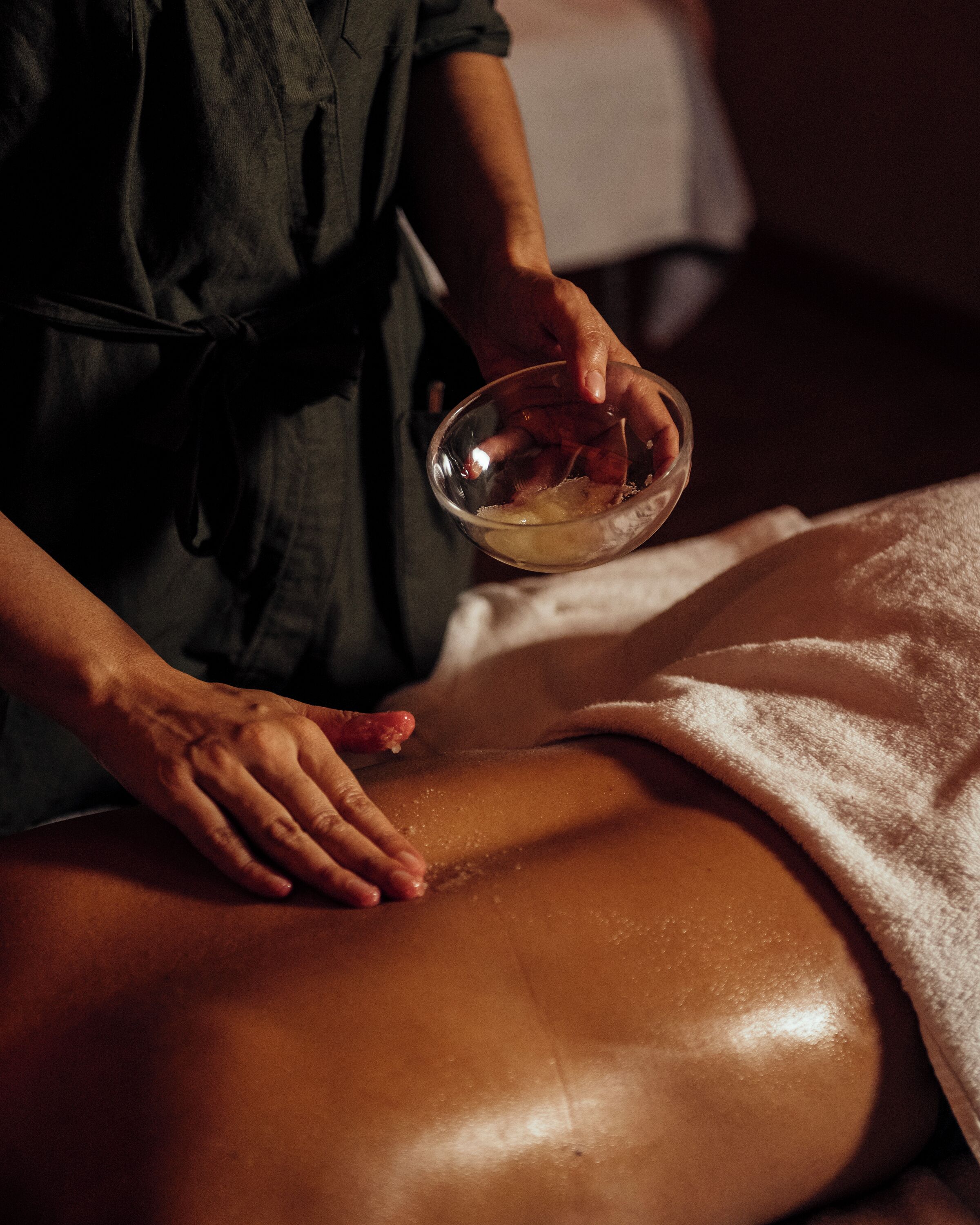 Uma pessoa recebendo massagem com uma toalha cobrindo a parte inferior do corpo.