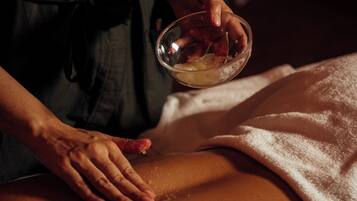 Uma pessoa recebendo massagem com uma toalha cobrindo a parte inferior do corpo.