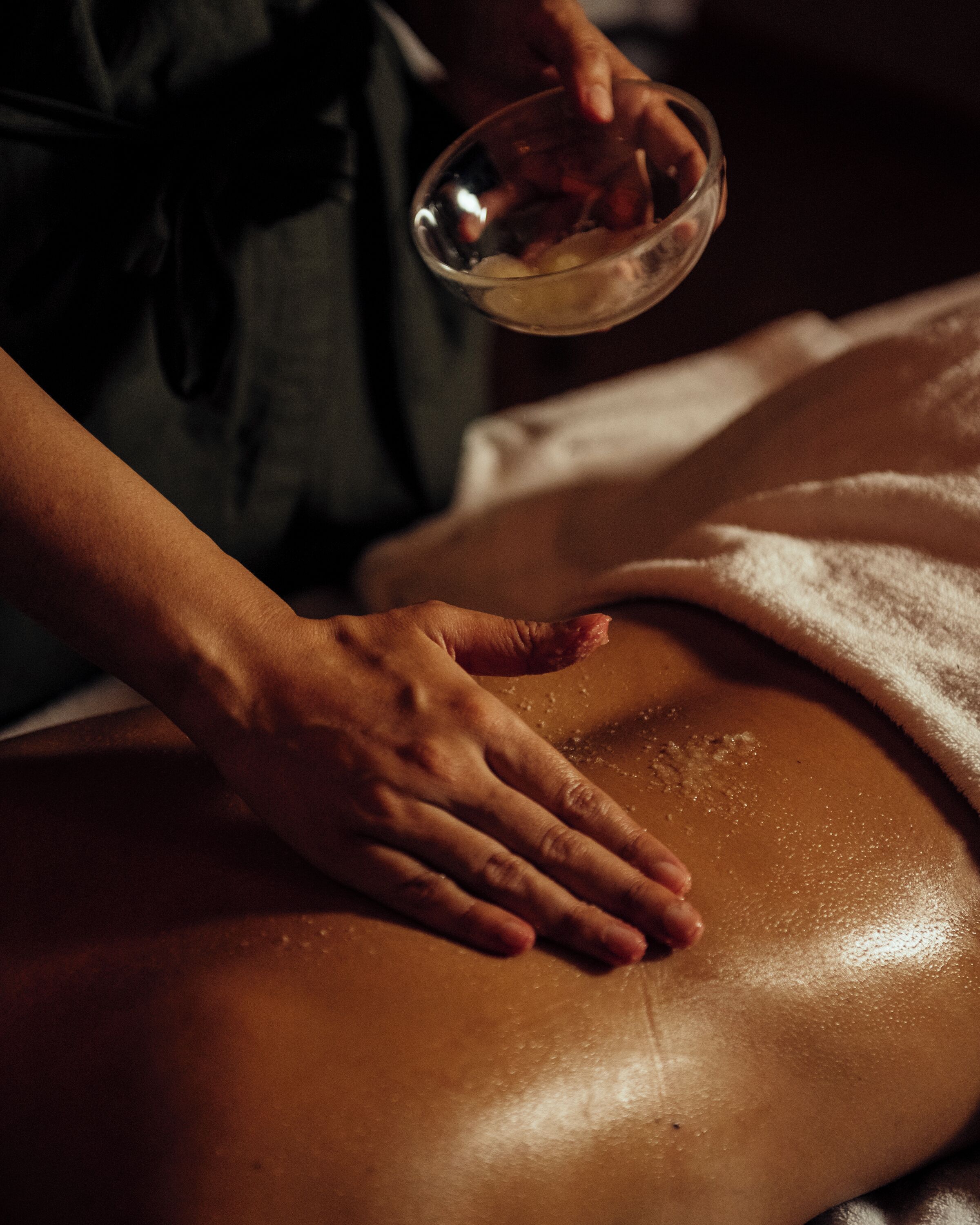 Eine Person erhält eine Massage, wobei insbesondere Hände und Rücken bearbeitet werden.